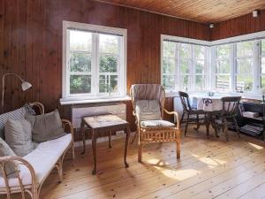 吉利勒杰6 person holiday home in Gilleleje的客厅配有桌椅和窗户。