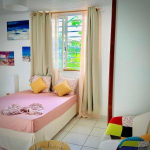 库鲁LE ROSA PARKS CLÉMARTHA的一间小卧室,配有粉红色的床和窗户
