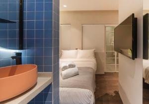 新加坡The Great Madras by Hotel Calmo的带浴缸、床和电视的浴室