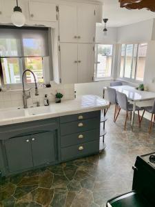 圣佩德罗Quiet3BD2BABikesDeckGarageLaundry的厨房配有绿色橱柜、水槽和桌子