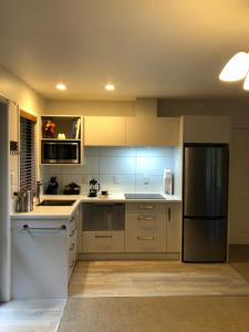 阿卡罗阿Cherrywood Cottage的厨房配有白色橱柜和不锈钢冰箱