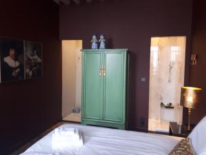 济里克泽Boutique Hotel Zeeuws-Meisje的一间卧室配有绿色橱柜和一张床