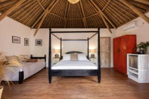 吉利阿萨汉Amahelia Luxury Resort & Restaurant - Gili Asahan的一间卧室,卧室内配有一张天蓬床