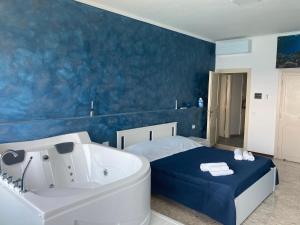 塔兰托Suite al mare的带浴缸的浴室和浴缸旁的床铺