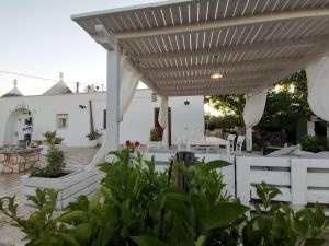 马丁纳弗兰卡Trullo Vito in Valle D itria con piscina的白色的庭院,设有白色的凉棚