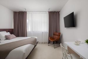 特罗吉尔Villa Biancomar的酒店客房配有一张床、一张书桌和一台电视。
