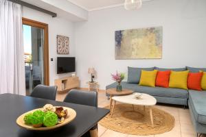 伊里斯斯Calma Guest House的客厅配有蓝色的沙发和桌子