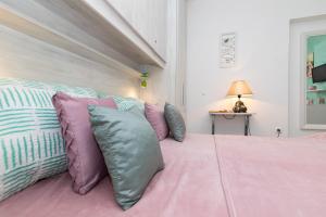 希洛Room Gržetić的一间卧室配有粉红色的床和紫色和蓝色枕头