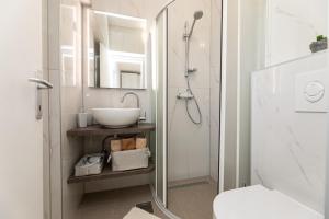 希洛Room Gržetić的浴室配有盥洗盆和带镜子的淋浴