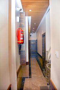 孟买Hotel Nest N Rest - Mumbai的大楼里带红色手提箱的走廊