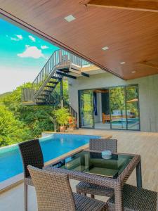 通奈潘海滩Baan View Talay Pool Villas的房屋设有1个带桌椅的游泳池