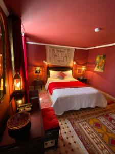 非斯让克洛德摩洛哥传统庭院住宅的一间卧室设有一张带红色墙壁的大床
