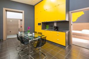 布达佩斯E14设计旅馆 的厨房配有玻璃桌和黄色橱柜