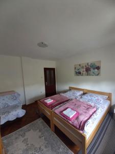 Vrhovine韦利科农家乐的一间卧室配有一张床,上面有两条毛巾