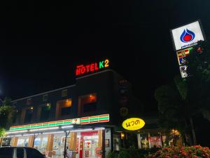 素叻机场K2酒店 的带有汽车旅馆标志和 ⁇ 虹灯标志的建筑