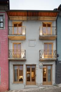 波尔图Na Travessa Suítes的公寓大楼设有2个阳台和窗户。