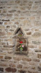 斯波莱托Non ditelo al Duca - Belvedere Sant'Angelo的砖墙,花瓶里放着鲜花