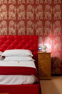 维罗纳Relais La Torre的红色的床,红色床头板在房间内