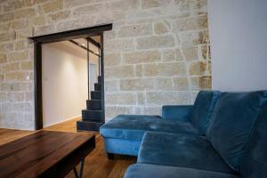 蒙彼利埃Le petit Corum - HH的客厅设有蓝色的沙发和砖墙