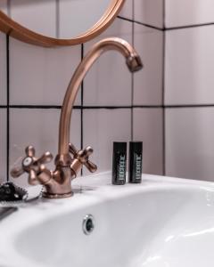 瓦伦西亚Hografic Hotel Boutique的浴室水槽配有水龙头和2把蜡烛