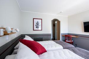 博伦厄Gylle Hotell & Restaurang Brödernas的一间卧室配有一张带红色枕头的大床