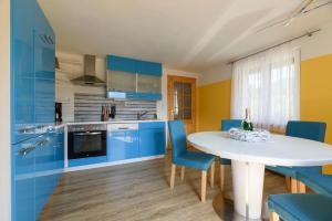 帕斯格许特路旁鲁斯巴赫特林德公寓的厨房配有蓝色橱柜和白色的桌椅