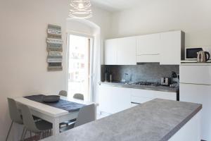 托尔博莱Nirvana Apartments的厨房配有白色橱柜和桌椅