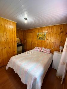 乌鲁比西Recanto do També的一间卧室配有一张带木墙的大床