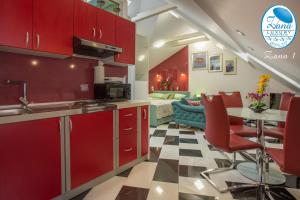 斯普利特Zana Luxury Studios Split center的厨房配有红色橱柜和桌椅