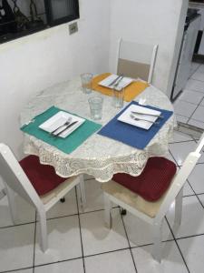 奥萨斯库Quarto INDIVIDUAL Casa Super Aconchegante WIFI 350 MEGA的一张桌子、一张白色的桌布和两把椅子