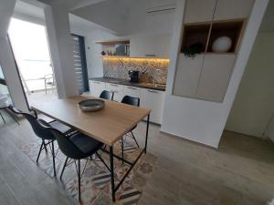 赫尔采格诺维Panorama Apartments的厨房配有木桌和椅子