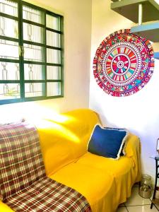 奥萨斯库Quarto INDIVIDUAL Casa Super Aconchegante WIFI 350 MEGA的墙上有盘子的房间的黄色沙发