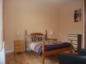 Achill SoundKatie's Cottage的一间卧室配有一张木架床和床头柜