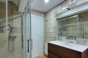 库迪列罗El Cuquiellu Cudillero centro的带淋浴、盥洗盆和镜子的浴室