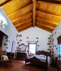 摩亚Vv LOS SENDEROS FONTANALES的一间卧室设有一张床和木制天花板