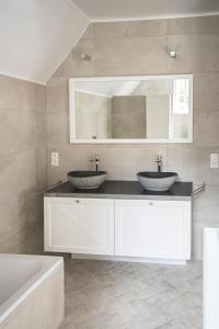 达默Tilia的浴室设有2个水槽、浴缸和镜子