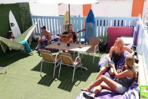 大加那利岛拉斯帕尔马斯Pura Vida Las Palmas的一群人坐在一张桌子旁弹吉他