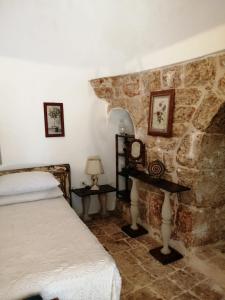 弗兰卡维拉丰塔纳Il Trullo del Cadetto的一间卧室设有一张床和石墙