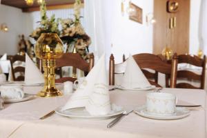 金斯海姆-古斯塔夫斯堡阿尔特波斯特卡尼酒店的一张桌子,上面有白色的桌布和餐巾
