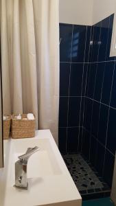 萨莱比梅Mango Villa的浴室配有水槽和蓝色瓷砖淋浴。