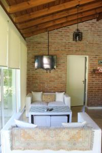 贝纳维德斯Paraiso Encontrado的客厅配有沙发和砖墙电视