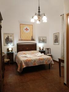 渥尔特拉Locanda Prato d'Era的一间卧室配有一张床和一个吊灯