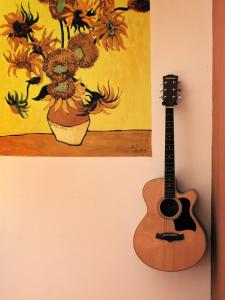 青岛青岛麦子青年旅社的挂在画旁墙上的吉他