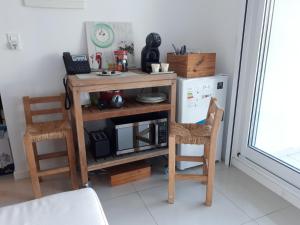 埃斯特角城Estudio con parrillero y vista al mar的厨房配有木桌和两把椅子