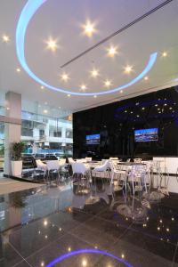 新加坡Arton Boutique Hotel的大楼内一家带白色桌椅的餐厅