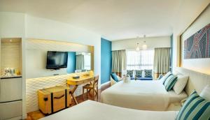 乔木提恩海滩乔木提恩棕榈滩度假酒店 - SHA Extra Plus的酒店客房配有两张床和一张书桌