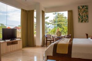 乌鲁瓦图巴厘岛独家别墅的一间卧室设有一张床和一个大窗户