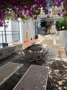 斯佩隆加Case Vacanze Ganimede的紫色花树下的野餐桌和椅子