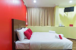 八打灵再也Hotel Sunjoy9 Bandar Sunway的一间卧室配有红色和白色枕头的床