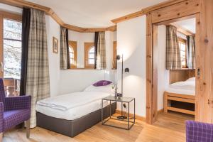 采尔马特Hotel Bella Vista Zermatt的卧室配有一张床和一张桌子